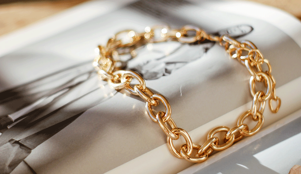 gold chain bracelet sits on magazine