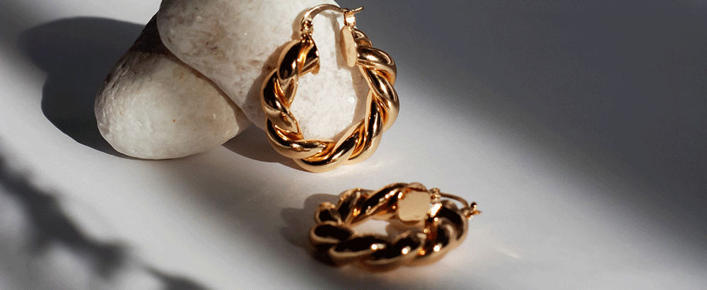 Two earings; One resting against a rock.